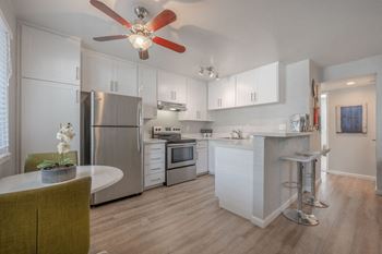 a kitchen with white cabinets and a ceiling fan at Napa Green Apartments LLC, Napa, 94559